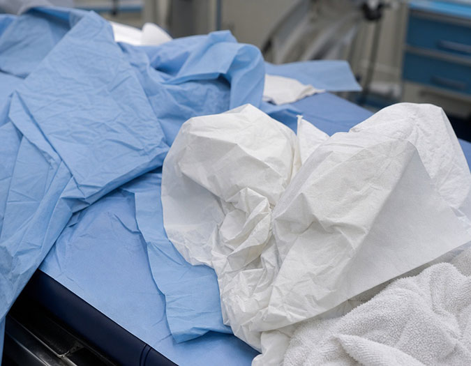a hospital bed with crumpled disposable materials